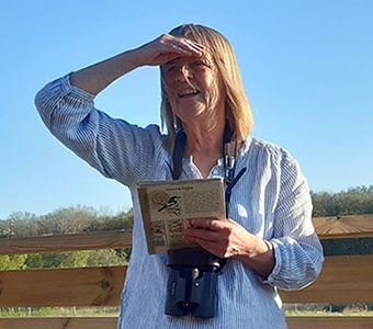Charlotte Lundberg, kommunekolog, skådar fågel.